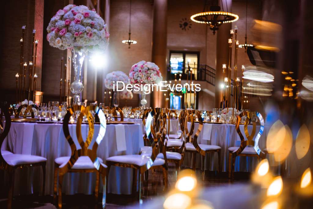 Elegant event setup with floral centerpieces and warm lighting.