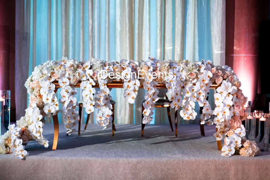 Elegant floral arrangement with cascading white orchids on a table.