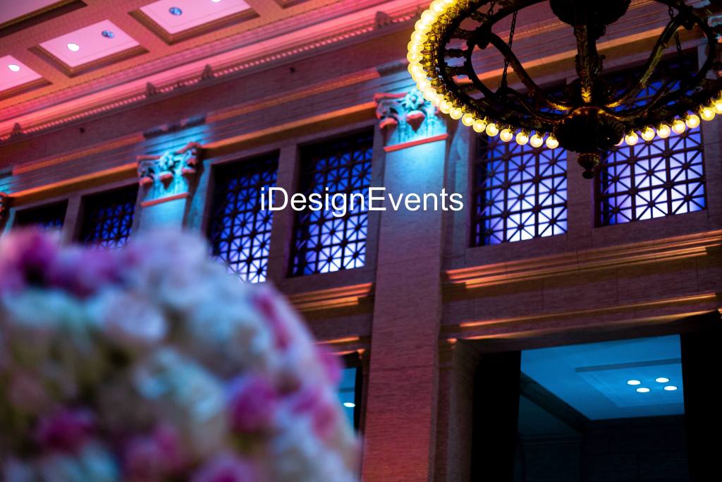 Elegant event space with colorful lighting and floral decor.