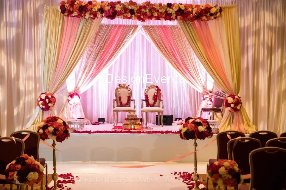 Elegant wedding stage with floral decorations and two chairs.