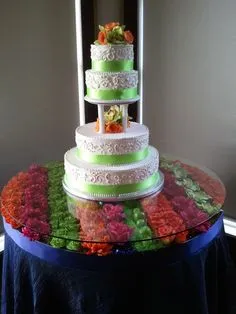 A tall, multi-tiered cake with green and white frosting on a decorated table.