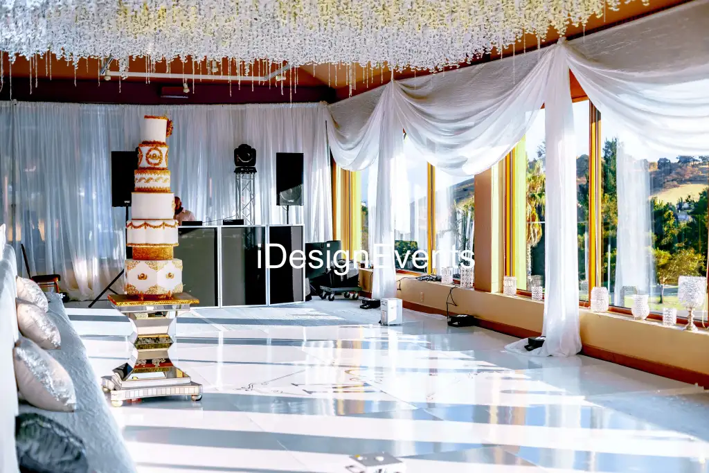 Elegant wedding venue with draped ceilings and a tall cake display.