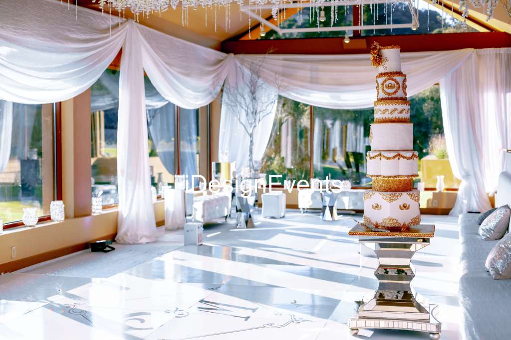 Elegant wedding venue with white drapes and floral decor.