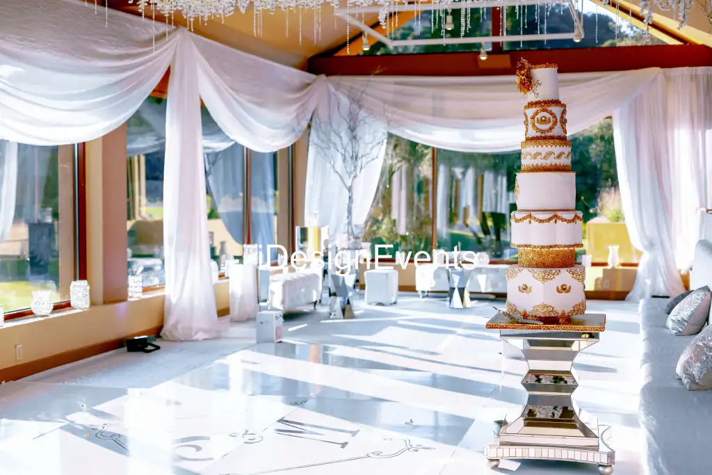 Elegant wedding venue with white drapes and floral decor.