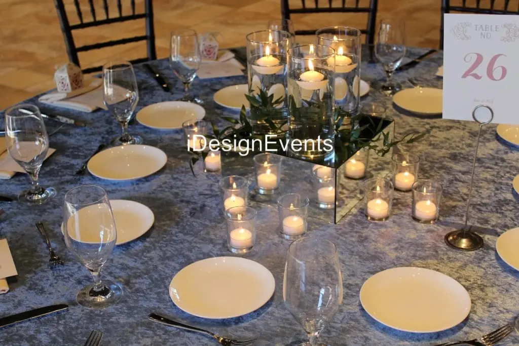 Elegant table setup with candles and glassware for a cozy event.