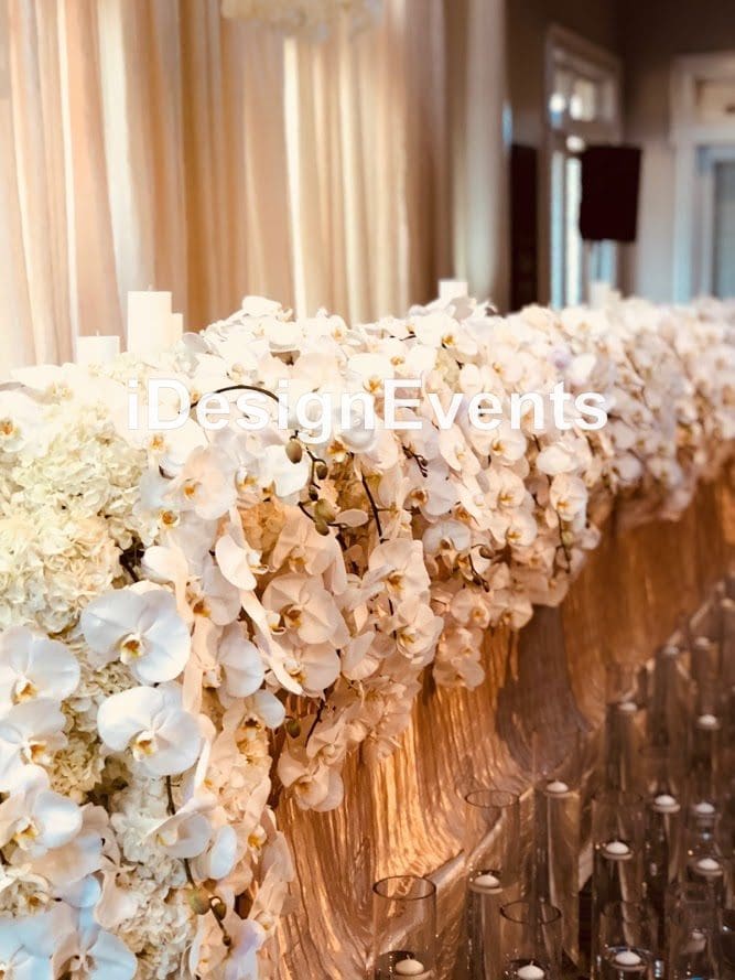 Elegant table decorated with cascading white orchids and soft lighting.