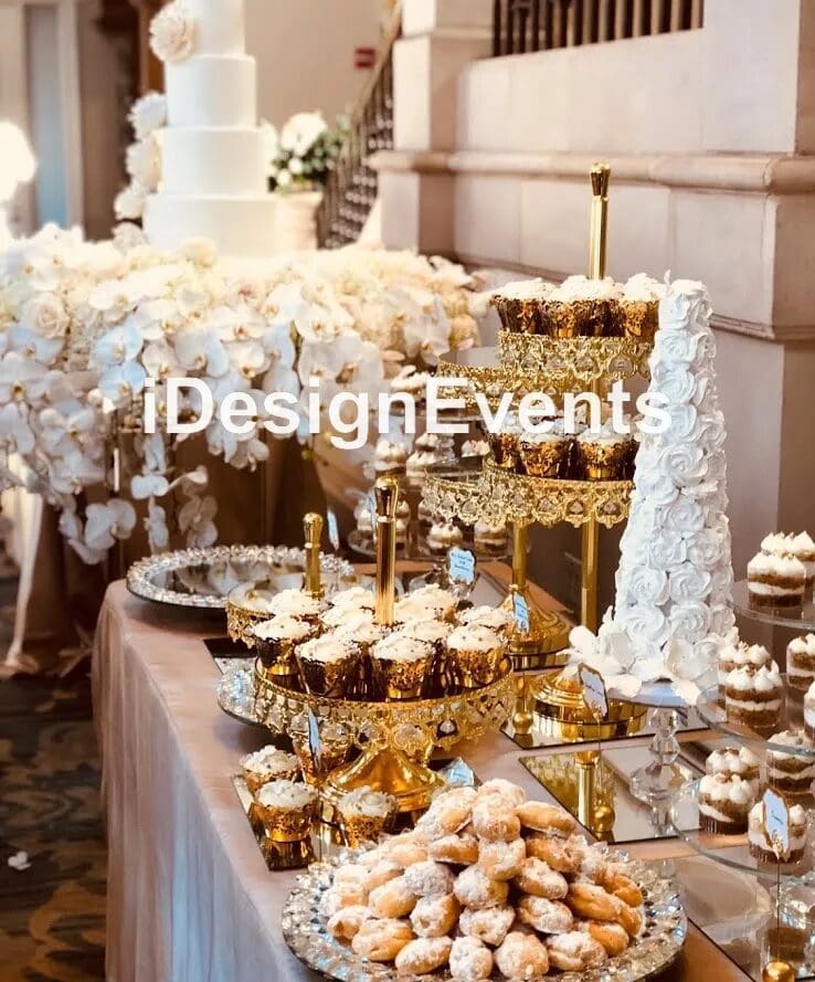 Luxurious gold-themed dessert table with elegant floral decorations.