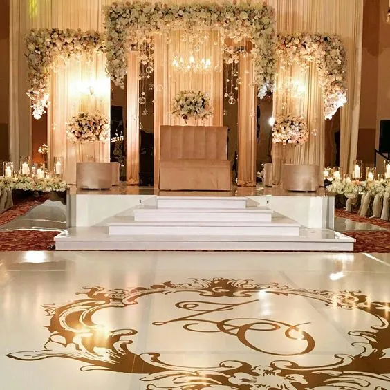 Elegant wedding stage with floral decorations and golden accents.