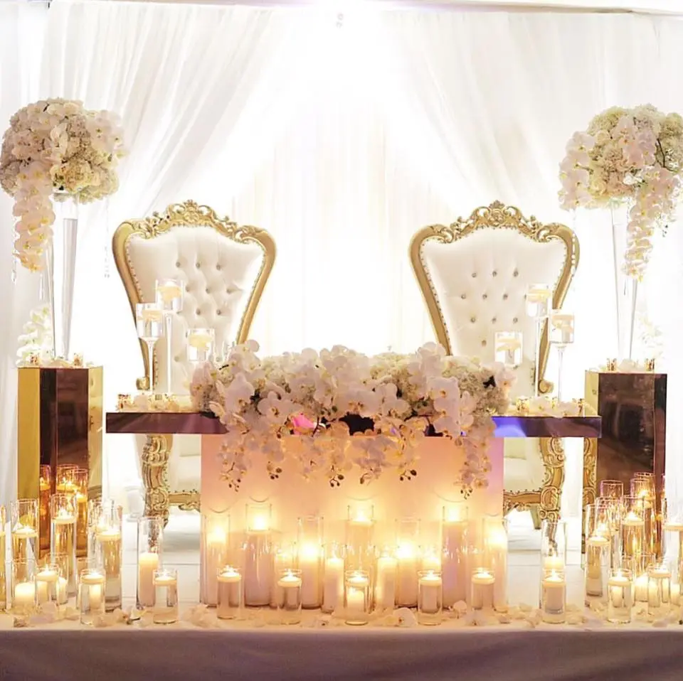 Elegant wedding stage with floral decorations and glowing candles.