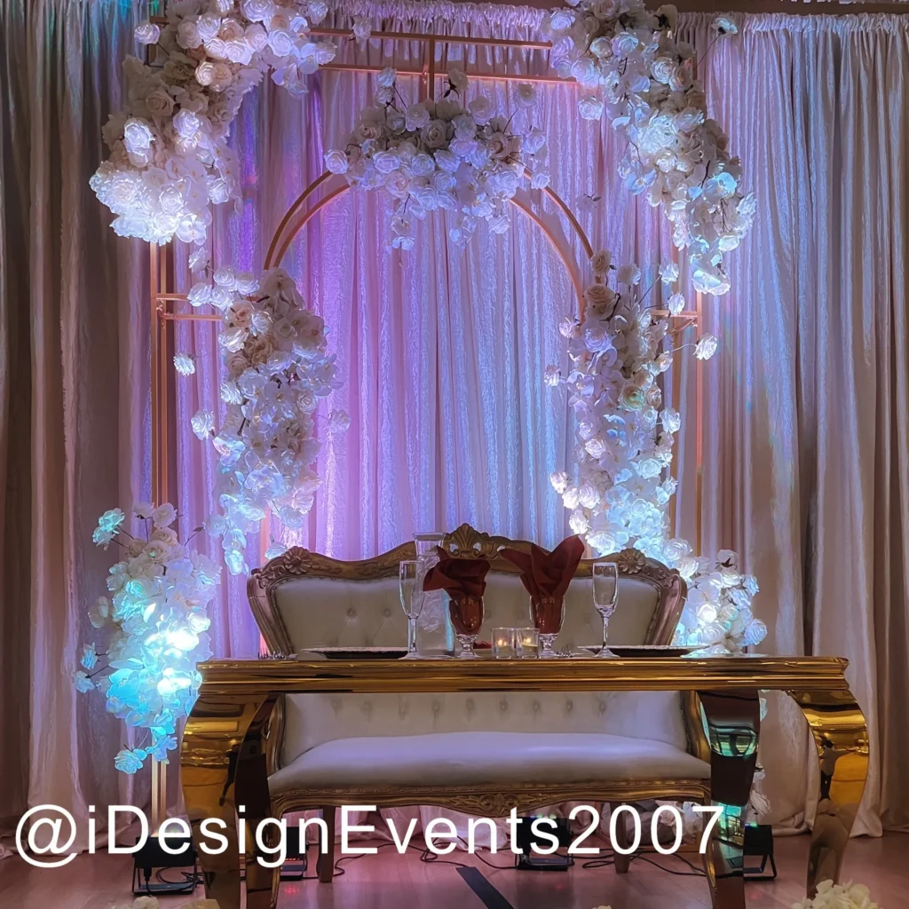 Elegant wedding altar with floral arch and soft lighting.