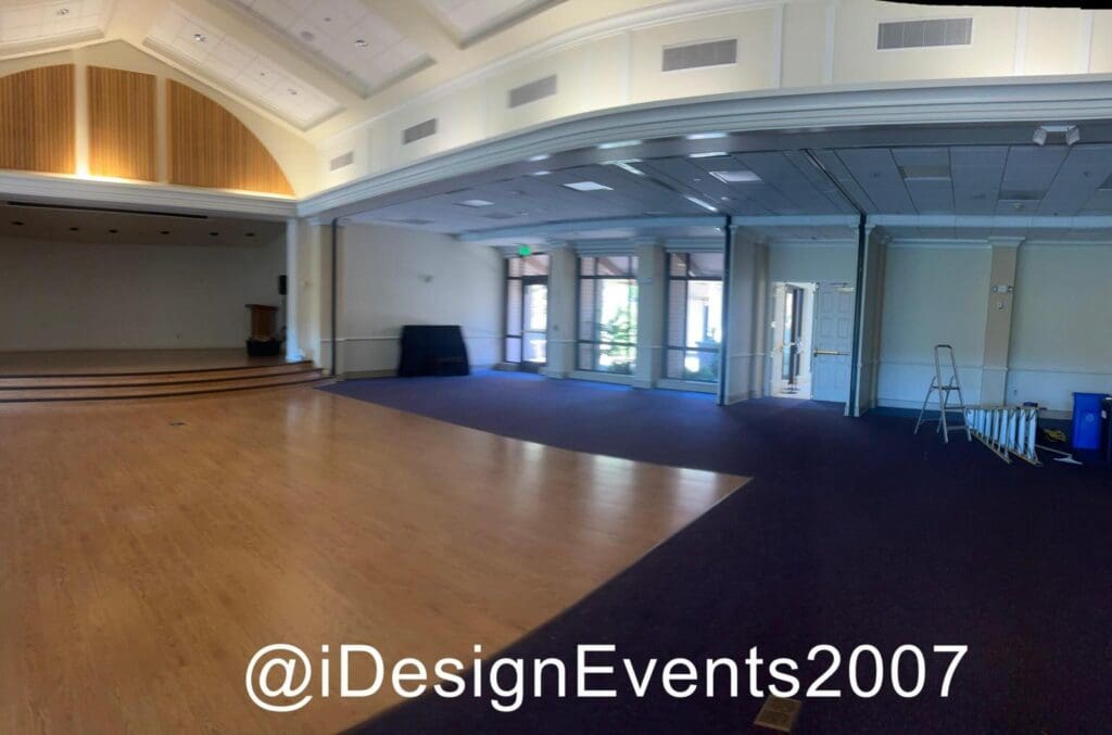 Spacious, elegant event hall with polished wooden floors and large windows.